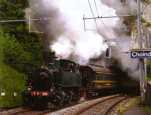 [«Volldampf im Jura.» Mallet ed 2 x 2/2 mit Salonwagen der OeBB bei der Einfahrt in den Bahnhof Choindez.]